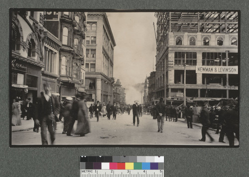 [Onlookers in Stockton St. at Geary. Union Square at far right; fire in distance.]