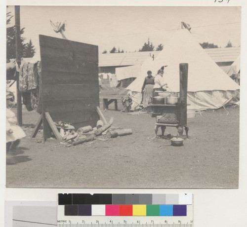 [Outdoor kitchen and wood-chopping area in refugee camp. Golden Gate Park.]