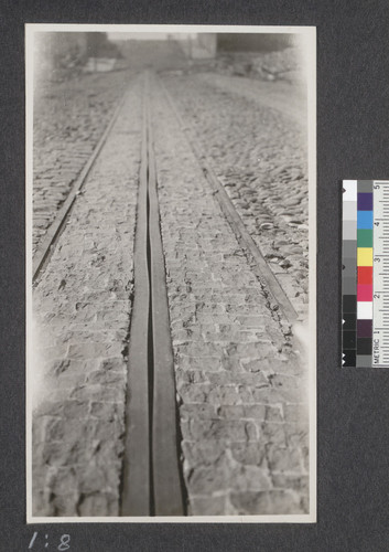 Cable track on Jones Street between Bush and Pine Streets. This also shows how the tops of all the cobble stones have been cracked off by the intense heat. May 25, 1906