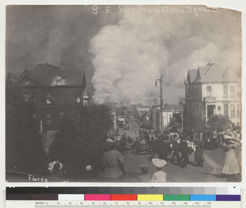 S.F. Fire from Almo [sic] Square. April...[illegible] 1806 [sic]. [People gathered in Alamo Square to watch fire to the east down Grove Street. St. Ignatius Church and College on fire in distance, right center. San Francisco. 1906. Photo by Florey.]