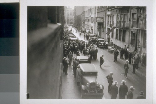 [View from 2nd floor window showing crowd of people in street]