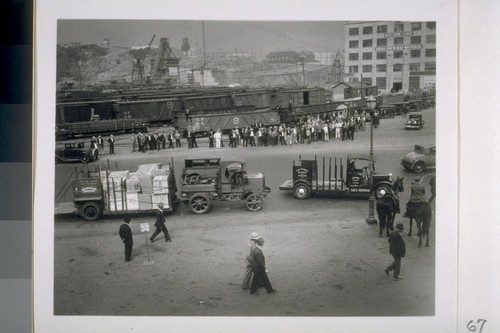 [Group congregating on street in front of railyard]