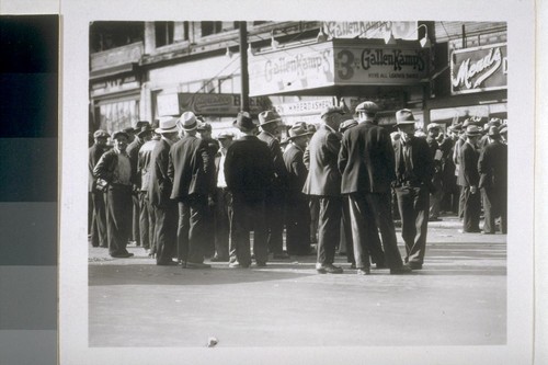 [Large crowd of men in street]