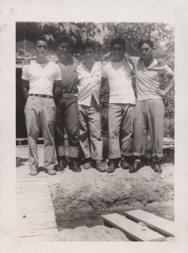 Five men standing by a wooden bridge at Poston incarceration camp