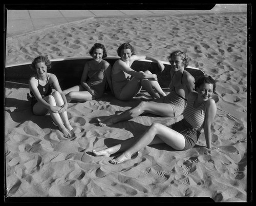 Los Angeles City College students on beach with surfboard, circa 1933-1938