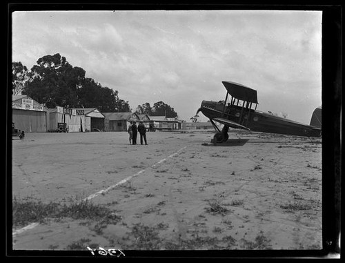 Biplane and men at airfield, [1920s?]