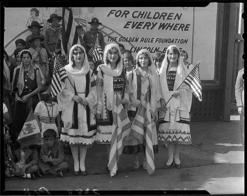 Group in Greek ethnic dress posing with billboard advertising Golden Rule  Week at Golden Rule Foundation Pageant, Los Angeles, 1930  Calisphere