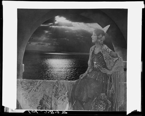 Montage photograph of young woman in arched window at sunset, [1920-1939?]