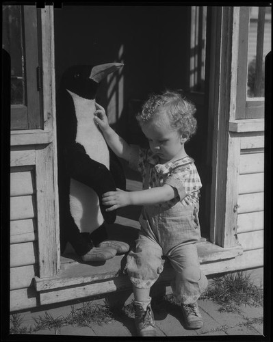 Child with toy penguin, Los Angeles, circa 1935