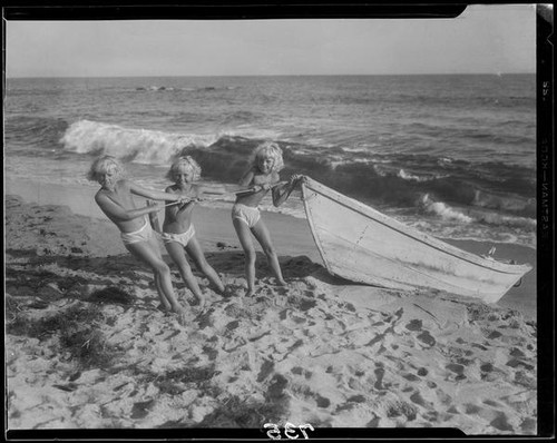 Mawby triplets with a rowboat on the beach, Malibu, 1928