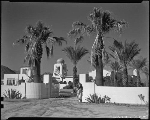 El Kantara, house with onion dome, horseshoe arches, and tiled roof, with woman at gate, Palm Springs, [1930s or 1940s?]