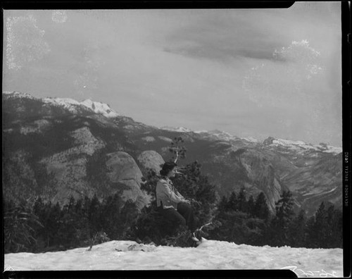 Young woman seated in tree over river rapids, Yosemite National Park, 1941