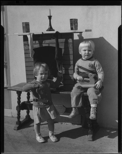 Children at model fireplace with stockings, Los Angeles, circa 1935