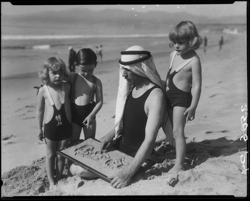 Patsy, Peggy, and Tommy Morgan on the beach with Eugene d'Orange, Santa Monica, 1929