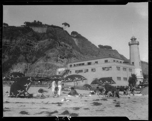 Lighthouse-shaped building, beach, and cliffs, Pacific Palisades, 1930