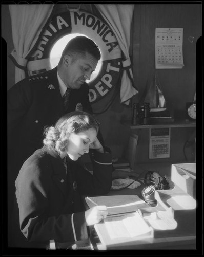 Actress Boots Mallory and an official in a Santa Monica harbor Department office, Santa Monica, 1937