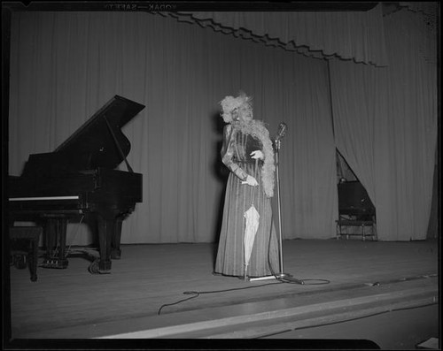 Lucille S. King, actress and ventriloquist, on stage singing, 1951