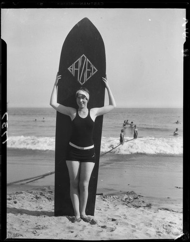 Woman posing with surfboard, Long Beach, 1929