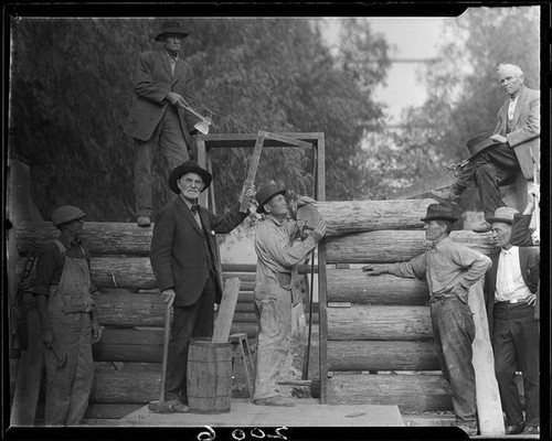 Men building log cabin, San Bernardino, 1925-1928