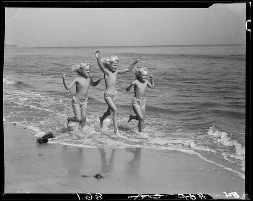 Mawby triplets running in surf, Malibu, 1928