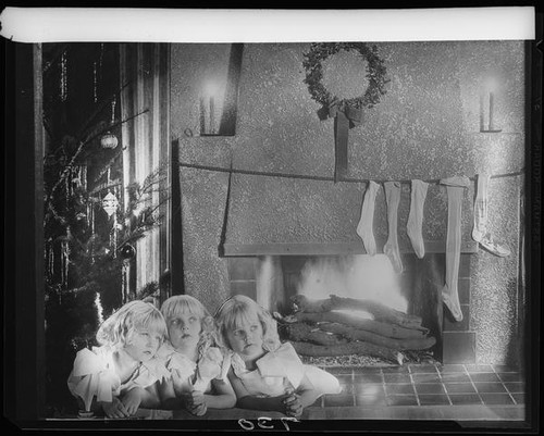 Montage photograph of Mawby triplets in front of fireplace with Christmas tree and stockings, Santa Monica, 1928