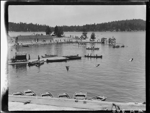 Dock area with canoes, rowboats, diving platforms, and people, Lake Arrowhead, 1929