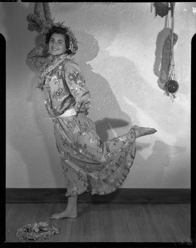 Young woman dancing in a muumuu and palm-frond hat, 1951