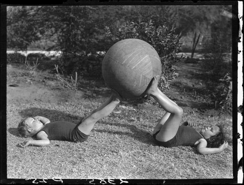 Two Estes children playing with exercise ball in a yard, [Van Nuys?], between 1928 and 1936