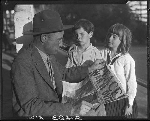 Veteran Leonard L. Deaver and two children with newspaper, Los Angeles, 1928 or 1930