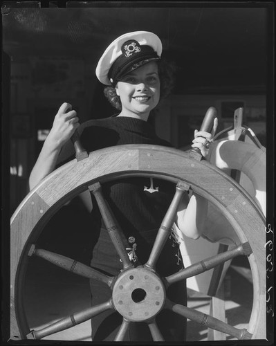 Actress Boots Mallory at a ship's wheel, Santa Monica, 1937