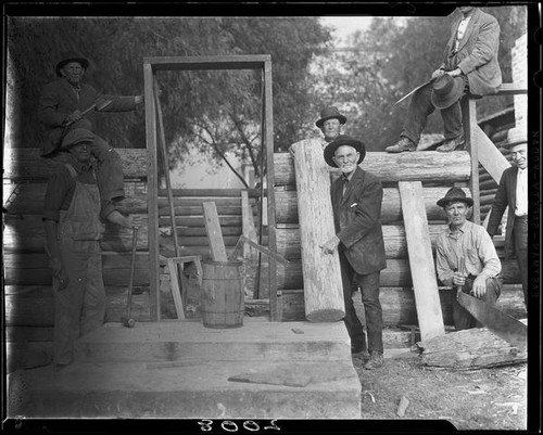 Men building log cabin, San Bernardino, 1925-1928