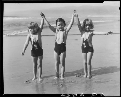 Patsy, Peggy, and Tommy Morgan posing on beach, Santa Monica, 1929