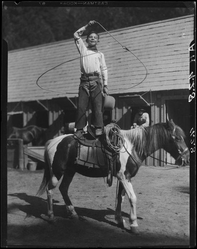 Child rodeo perfomer Little Buck Dale doing rope trick standing on ...