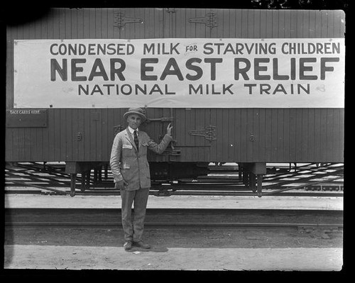 Adelbert Bartlett in front of railroad car with sign for Near East Relief, 1922-1929