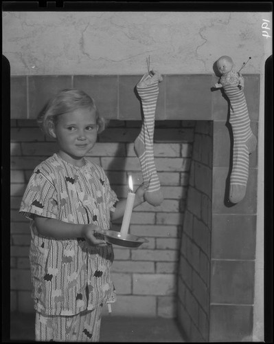 Girl with candle and Christmas stockings, Los Angeles, circa 1935