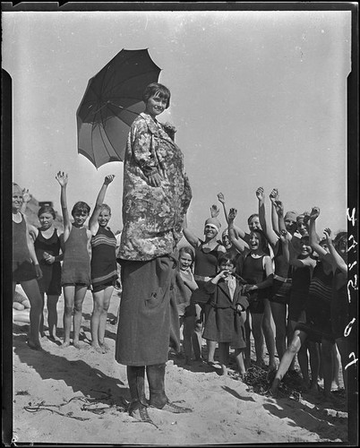 Child on adult's shoulders on beach, Pacific Palisades, 1927