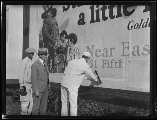 William Gibbs McAdoo and two men at billboard, Los Angeles, 1925 or 1927