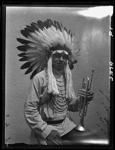 Young man in Indian regalia with trumpet, 1928