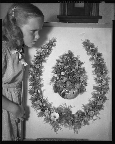 Young girl with horseshoe-shaped wreath of shells made in 1888 by poet Ina Donna Coolbrith, 1953