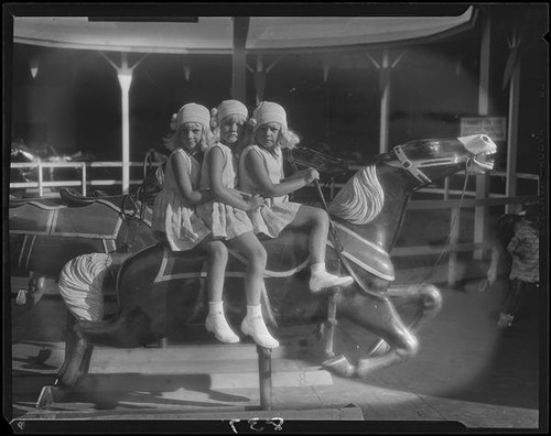 Mawby triplets on merry-go-round, Malibu, 1928