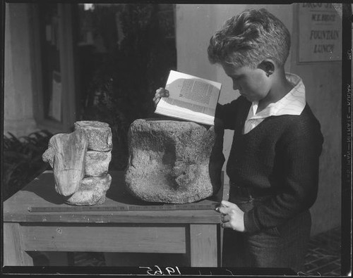 Boy with fossil rocks and book, Palos Verdes Estates, 1930 or 1931