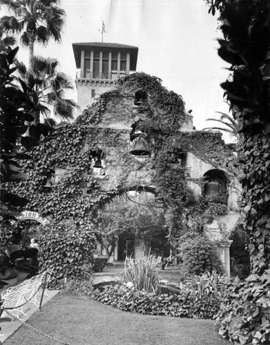 Ivy-covered bells stand in lush garden