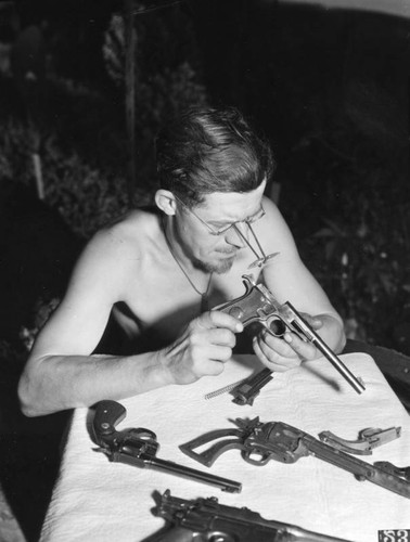 Man examining pistols