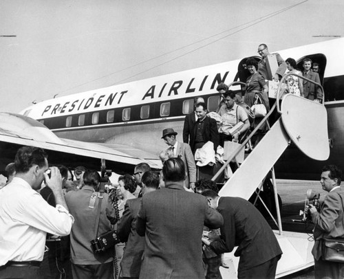 Tired, happy passengers on delayed flight disembark