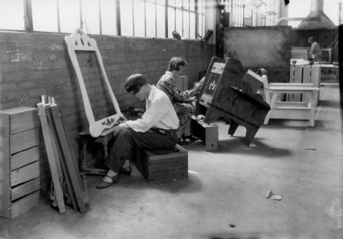 Women painting designs on furniture