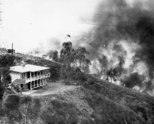 Flames approach a home