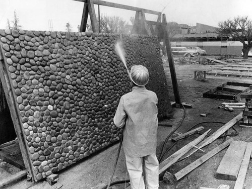 Workman washes down stone panel