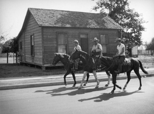 Three men riding horses