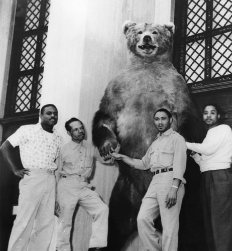 Museum workers with stuffed bear