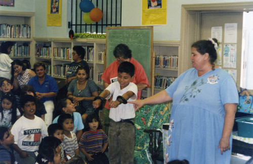 Young boy holding two snakes, Cypress Park Branch